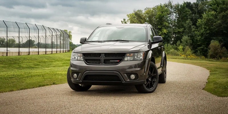 A Dodge Journey SUV parked next to a field