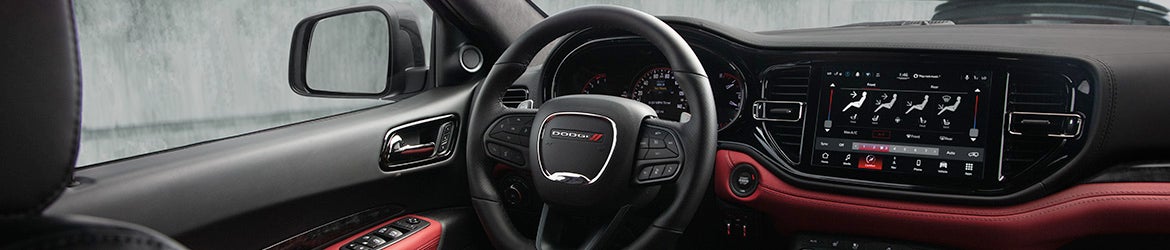 Interior of a Dudge showing steering wheel and infotainment system