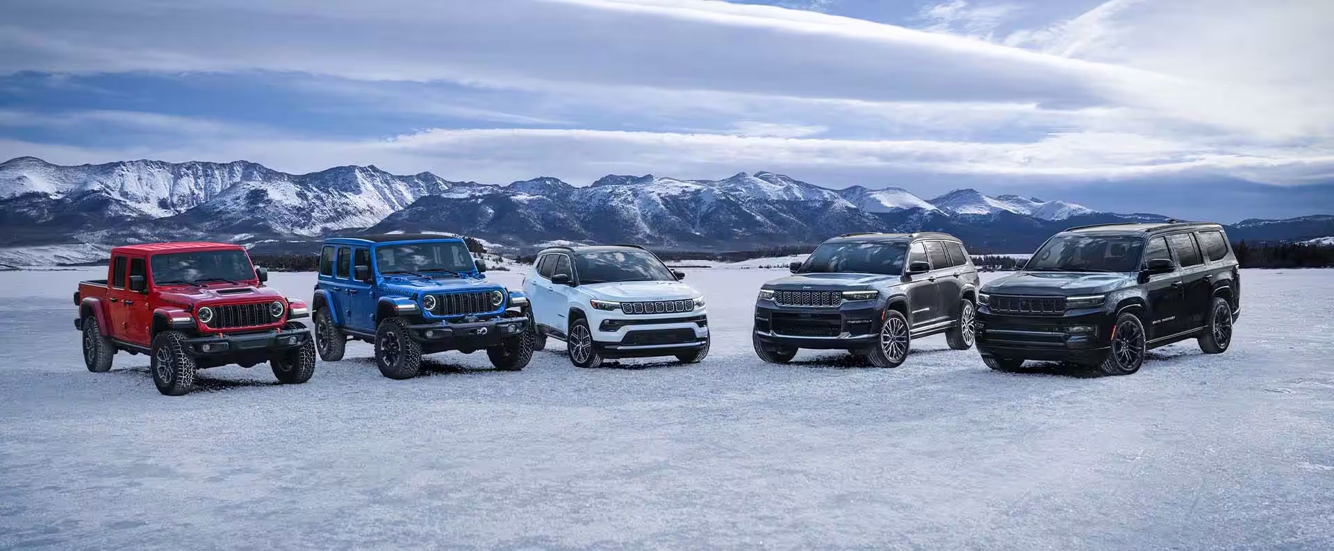 Line up of different Jeeps vehicles on snowy ground