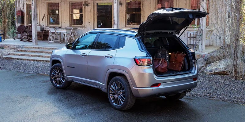 Gray Jeep Compass parked on the driveway with the trunk open