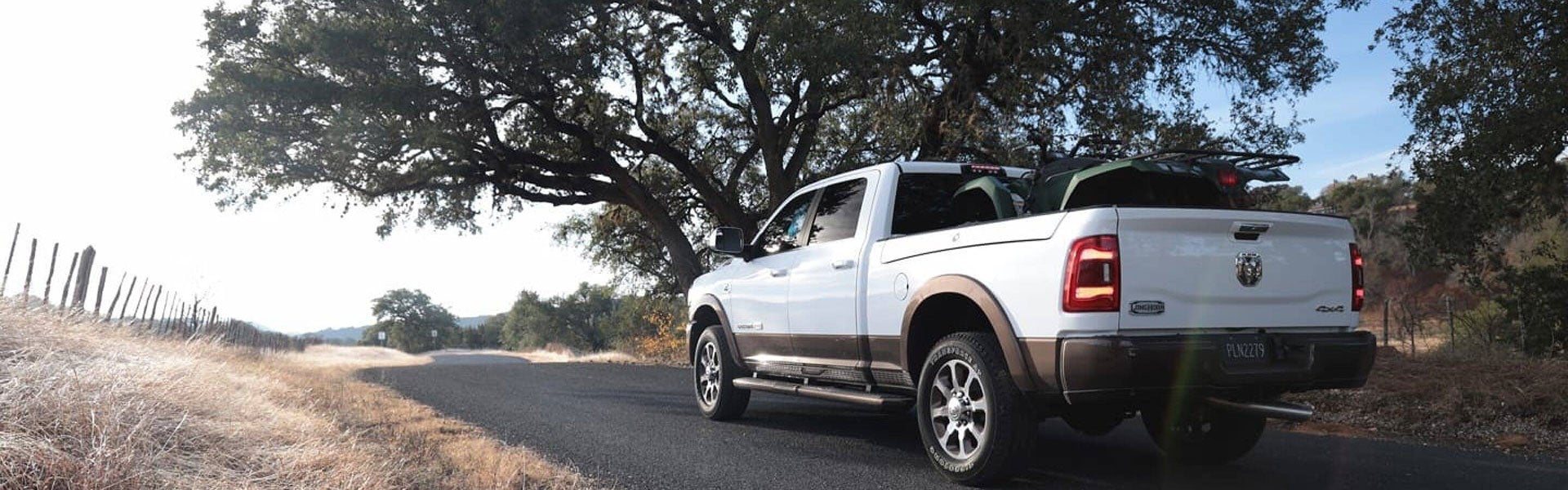White Ram 2500 parked on the side of the road next to a big tree
