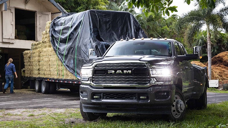 Black Ram 3500 showing its capabilities by pulling a whole other trailer with wood