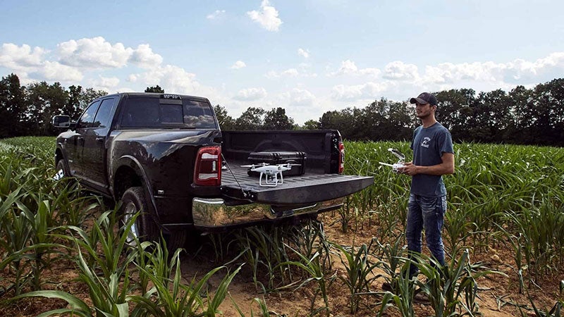 Man opening up the hatch of a Ram 3500 in the middle of the day on a farm