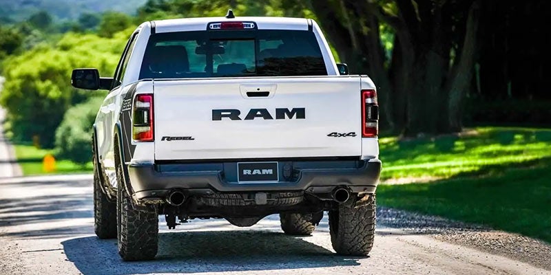 White Ram 1500 driving down the road on a hot and sunny day
