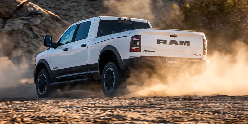 Ram pickup truck driving on dirt road