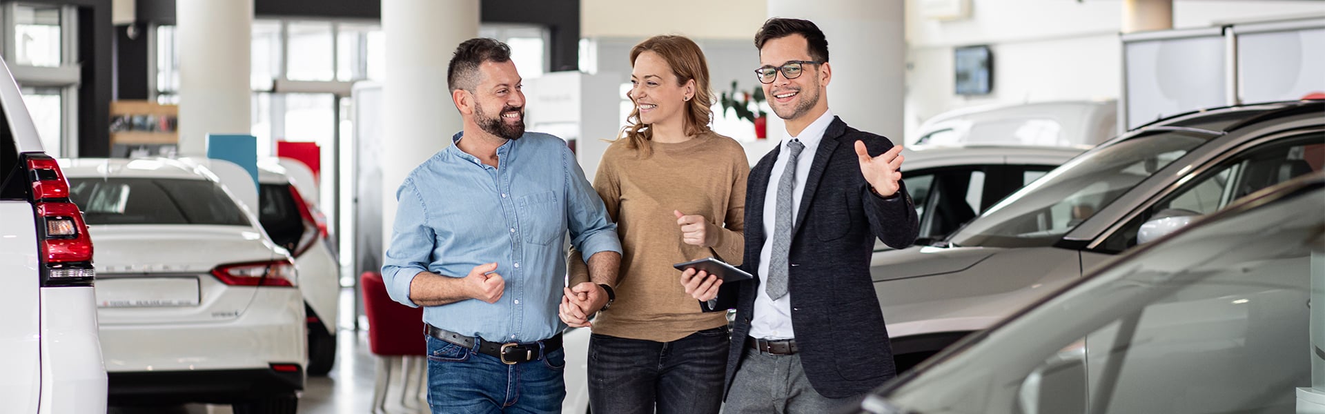 Couple holding hand while talking to salesman