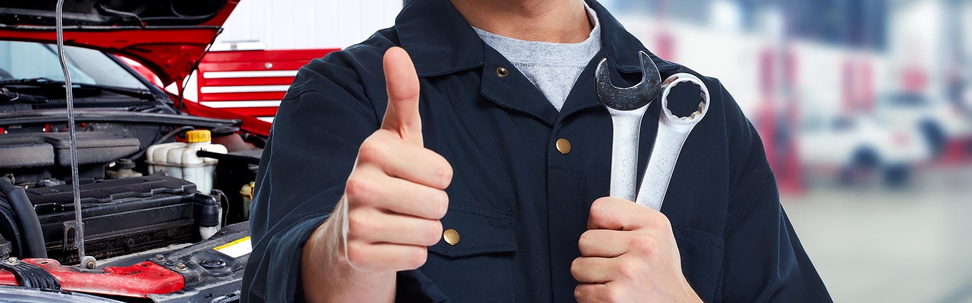 Mechanic give a thumbs up while the other hand holding wrench and socket